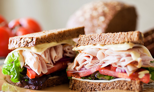 turkey and cheese sandwich with lettuce and tomatoes